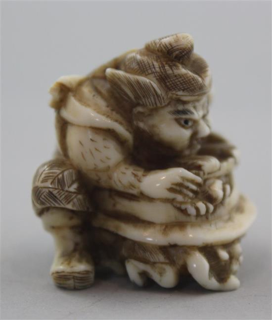 A Japanese walrus ivory netsuke of Shoki crushing two oni, signed Gyokuzan, Meiji period, 3.8cm